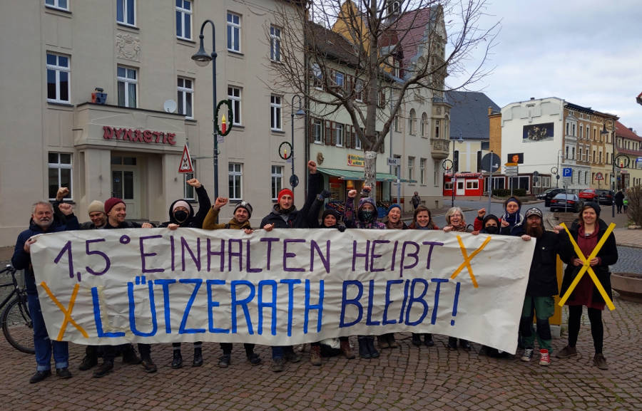 Auf dem Marktplatz in Taucha bei Leipzig: Ca. 20 Menschen mit einem Transparent mit der Aufschrift: 1,5° einhalten heißt: Lützerath bleibt!