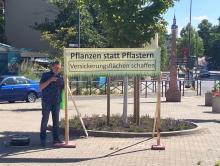 Banner mit der Aufschrift "Pflanzen statt pflastern - Versickerungsflächen schaffen" an der Bürgerruhe